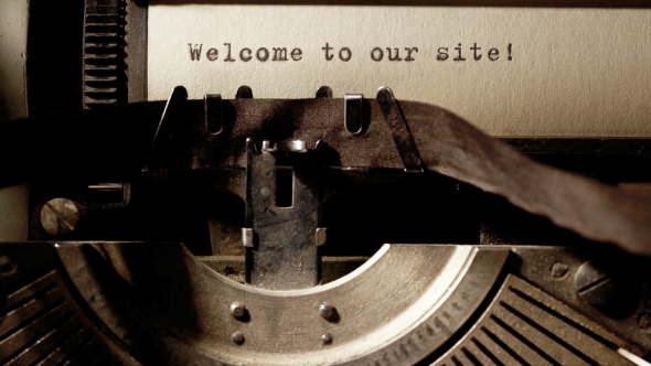 A photo of a typewriter with the words "Welcome to our site!" typed on the paper in the machine. 