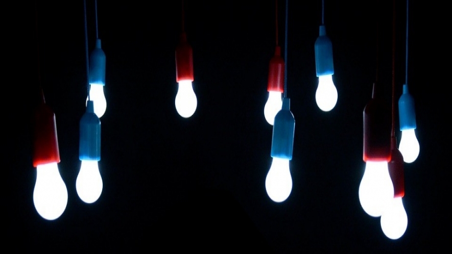 A photo of hanging light bulbs shining in the dark.