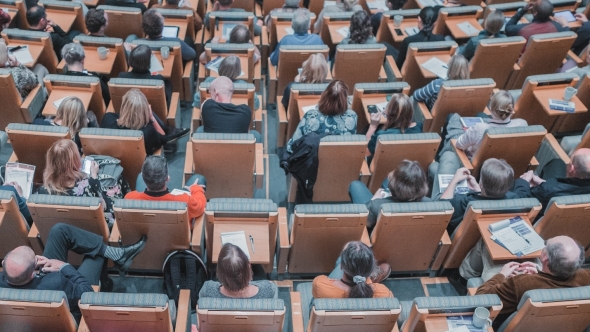 A photograph from above of students sitting in a lecture hall. 